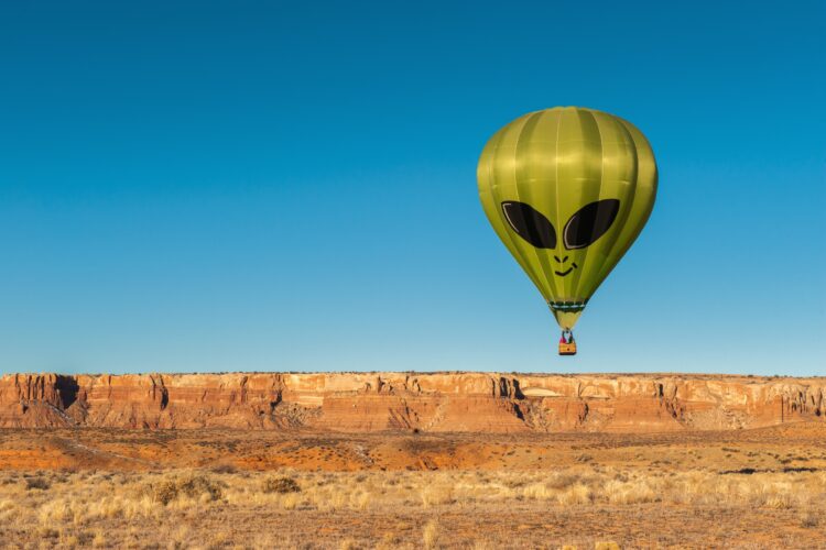 Alien hot air balloon over desert landscape.